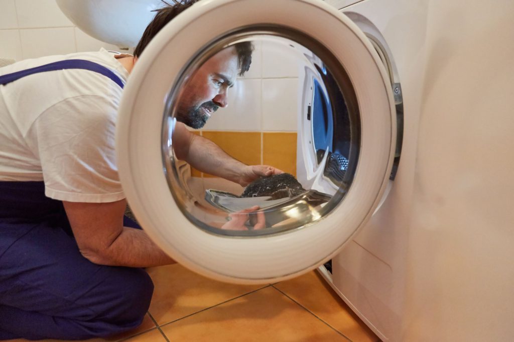 an image of repairman fixing a defy tumble dryer