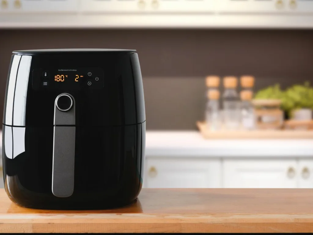 Repaired LG air fryer. This image shows a repaired LG air fryer. The air fryer is turned on, and the display is showing the time. The plastic housing of the air fryer is no longer cracked