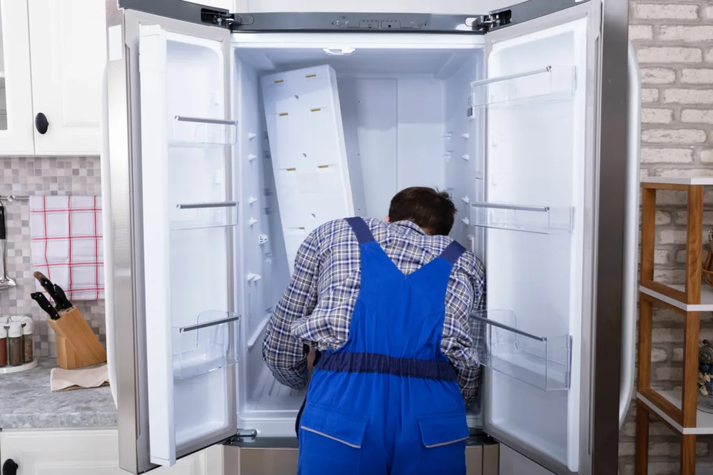 fridge technician examines fridge for repairs in westville