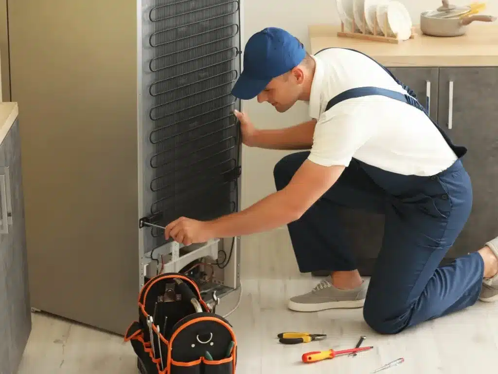 Kitchen appliance repair technician fixing a fridge in westville