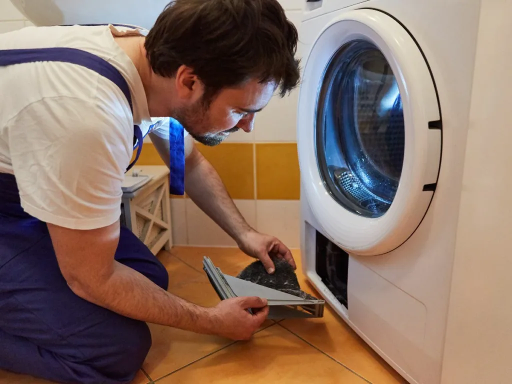 Appliance repair technician fixing a tumble dryer in La Lucia, South Africa