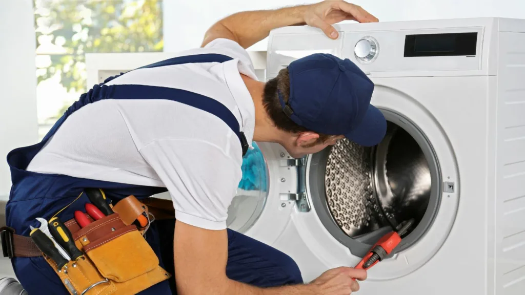 A person repairs an appliance in a kitchen near Kingsburgh.