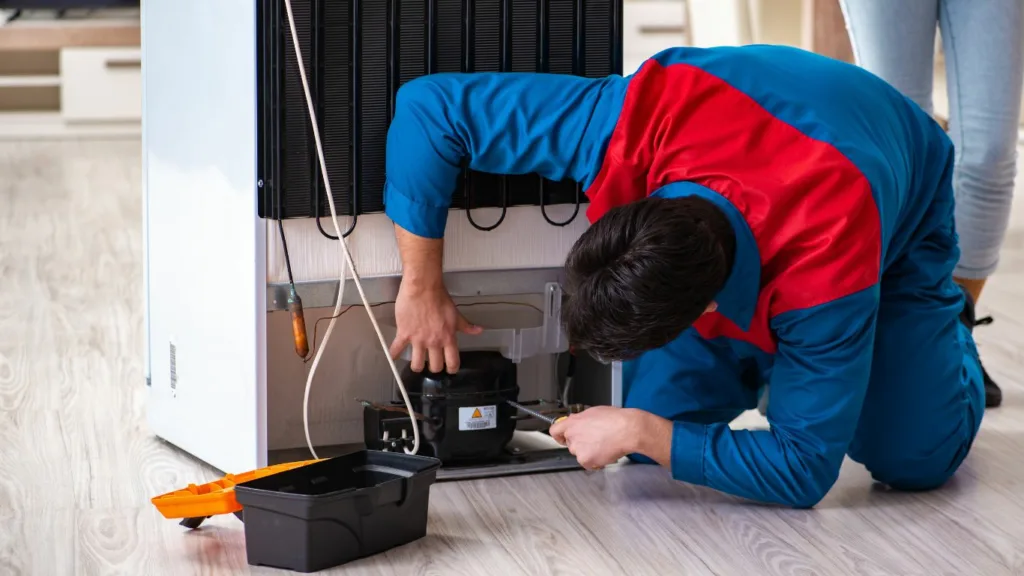 Technician inspecting a KIC fridge making noise in durban