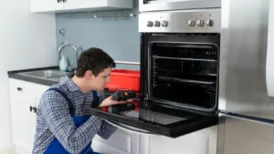 Skilled repairman diagnosing a faulty oven in Glenwood kitchen.