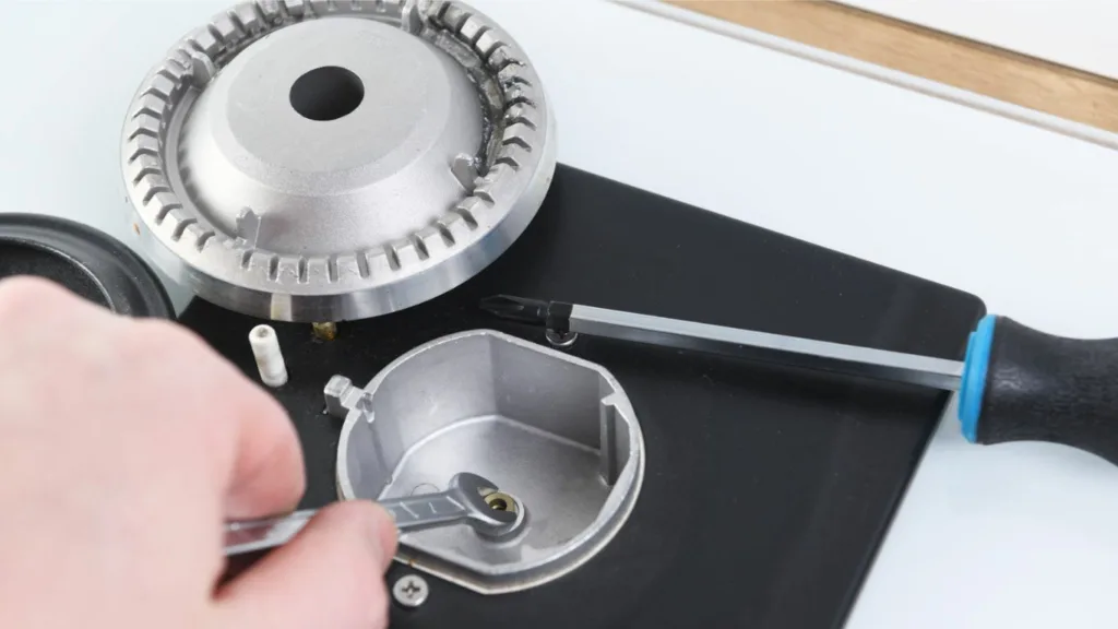 Close-up of a Smeg stovetop being serviced by a qualified technician.