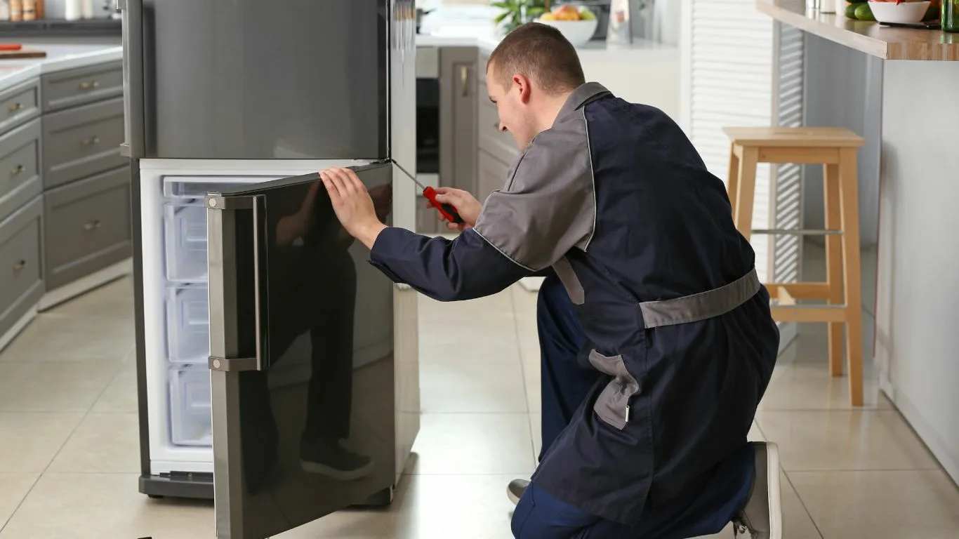 Fridge repair technician working on a refrigerator in Isipingo.