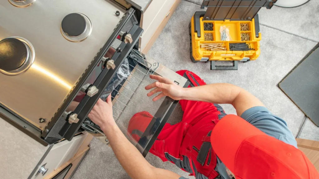 Technician repairing a stovetop in a Verulam home kitchen.