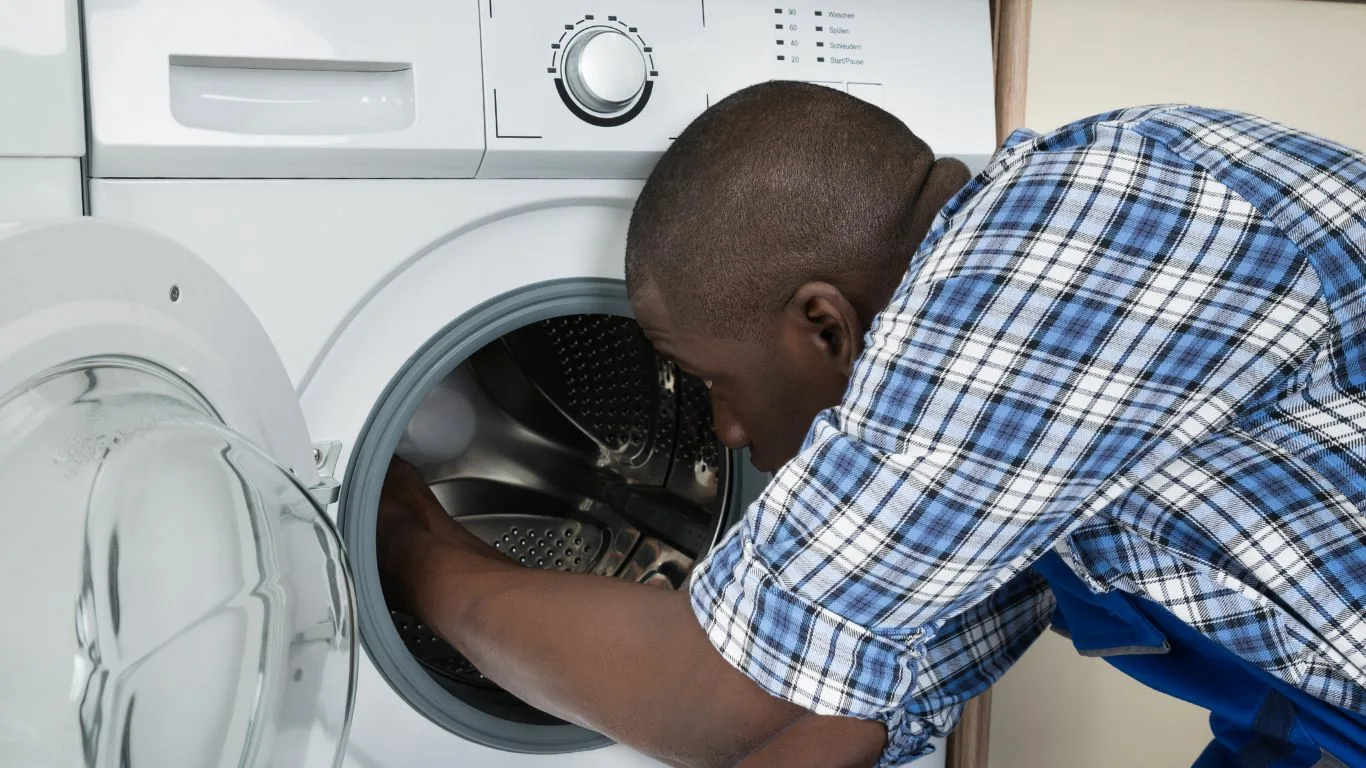 A professional fixing a washing machine in waterfall