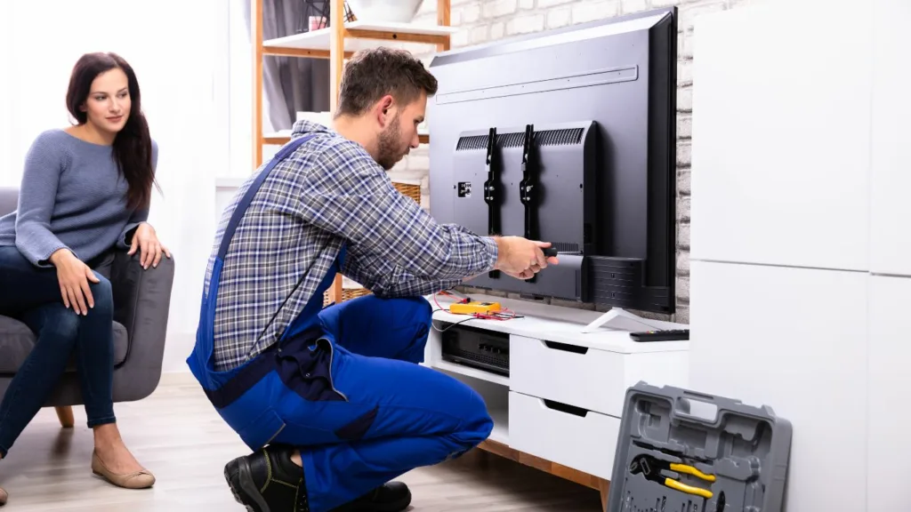 Technician carefully replacing the LCD screen of a Sinotec TV.