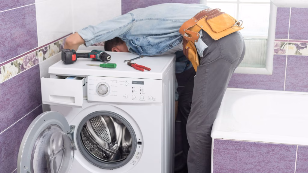 Technician repairing a front-load washing machine in a Durban home