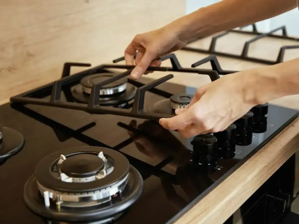 Close-up of a technician’s hands adjusting a gas stove burner in Mount Edgecombe. gas stove and burner repairs in mount edgecombe
