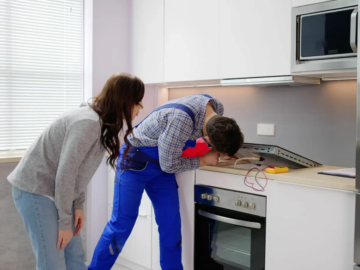 stove and oven repairs Electric stove repair technician in Berea, Durban replacing a faulty heating element. Call us for stove and oven repairs