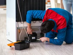 fix fridge seal- a technician is testing the seal around the door of a refrigerator to make sure it is properly sealed.